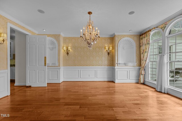 4315 Sugar Pine Ln, Durham, NC 27705 - unfurnished dining area with a chandelier, ornamental molding, wood finished floors, a wainscoted wall, and wallpapered walls