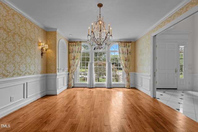 4315 Sugar Pine Ln, Durham, NC 27705 - unfurnished dining area featuring a chandelier, wainscoting, wallpapered walls, crown molding, and wood finished floors