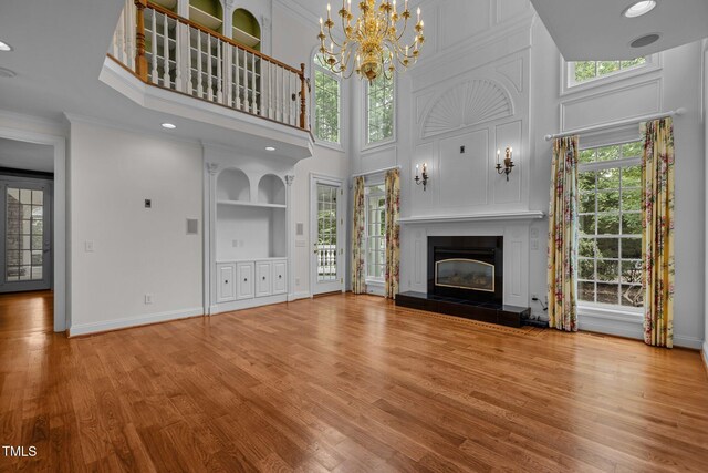 4315 Sugar Pine Ln, Durham, NC 27705 - unfurnished living room featuring plenty of natural light, wood finished floors, a high ceiling, a tile fireplace, and ornamental molding