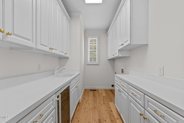 4315 Sugar Pine Ln, Durham, NC 27705 - laundry room with wine cooler, cabinet space, light wood-type flooring, washer hookup, and crown molding