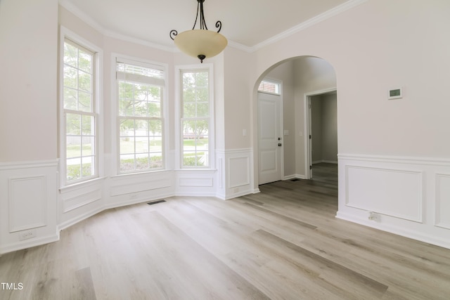 616 Cheselden Dr, Durham, NC 27713 - unfurnished dining area with arched walkways, wainscoting, light wood-style floors, a decorative wall, and crown molding