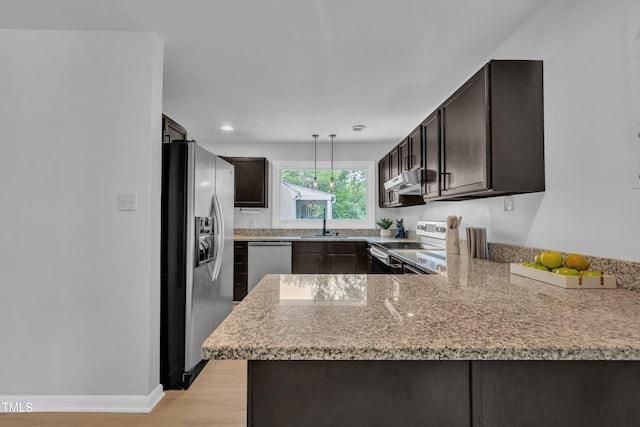 3205 Dell Dr, Raleigh, NC 27609 - kitchen featuring stainless steel appliances, light wood-style floors, a peninsula, extractor fan, and light stone countertops