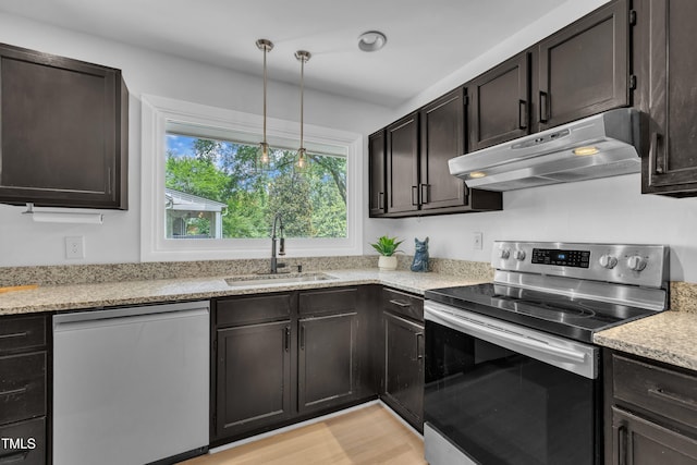 3205 Dell Dr, Raleigh, NC 27609 - kitchen featuring stainless steel appliances, under cabinet range hood, hanging light fixtures, and dark brown cabinetry