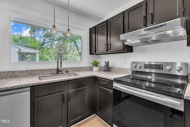 3205 Dell Dr, Raleigh, NC 27609 - kitchen with stainless steel appliances, under cabinet range hood, healthy amount of natural light, and hanging light fixtures