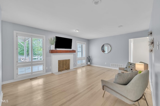 3205 Dell Dr, Raleigh, NC 27609 - living area with light wood-type flooring and a fireplace with flush hearth