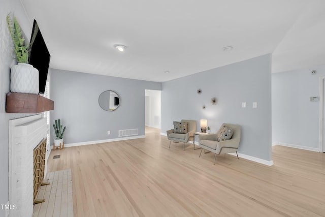 3205 Dell Dr, Raleigh, NC 27609 - sitting room with light wood-type flooring and a brick fireplace