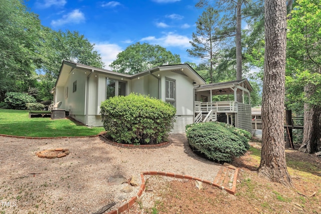 3205 Dell Dr, Raleigh, NC 27609 - view of side of home featuring ceiling fan, stairs, a yard, and a deck