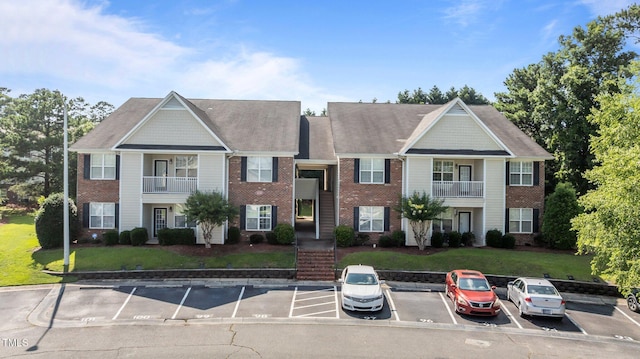 3159 Wisteria Ln Unit 202, Fayetteville, NC 28314 - view of front of home with brick siding, uncovered parking, a front yard, and a balcony