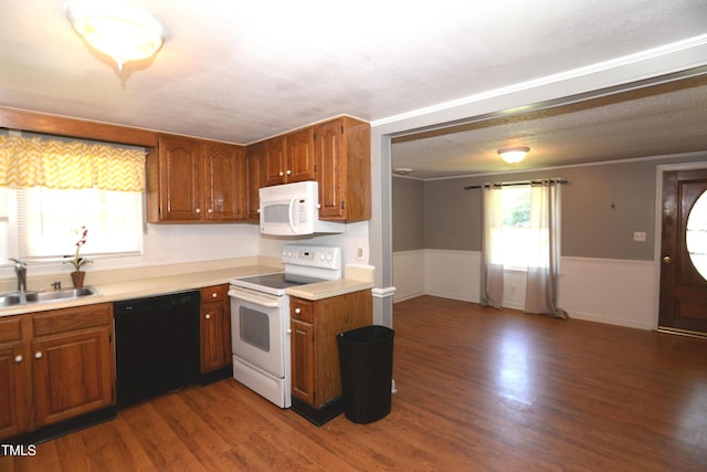 521 S Lombard St, Clayton, NC 27520 - kitchen with white appliances, light countertops, a wainscoted wall, dark wood-type flooring, and brown cabinetry