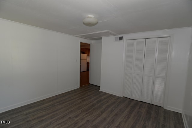 521 S Lombard St, Clayton, NC 27520 - unfurnished bedroom featuring freestanding refrigerator, dark wood-style flooring, and a closet