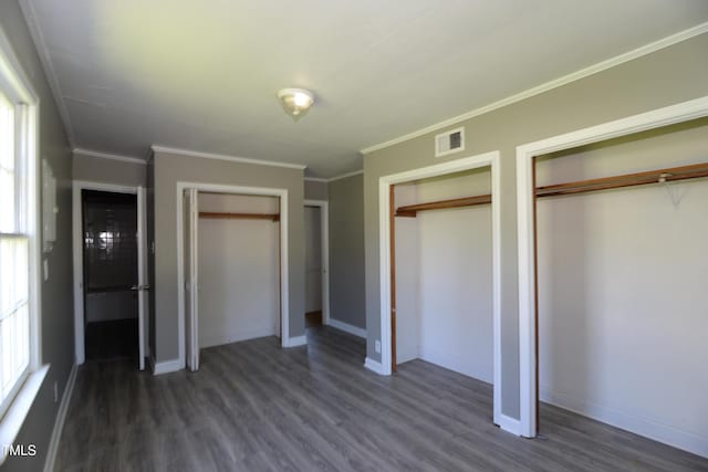 521 S Lombard St, Clayton, NC 27520 - unfurnished bedroom with two closets, dark wood-style floors, and crown molding