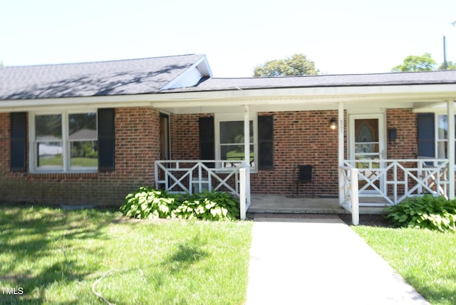 521 S Lombard St, Clayton, NC 27520 - view of front of home with covered porch, brick siding, and a front yard