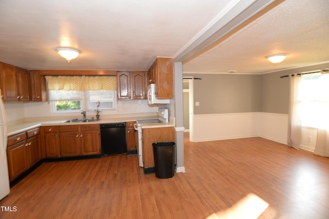521 S Lombard St, Clayton, NC 27520 - kitchen featuring white appliances, brown cabinets, light countertops, light wood-style floors, and open floor plan
