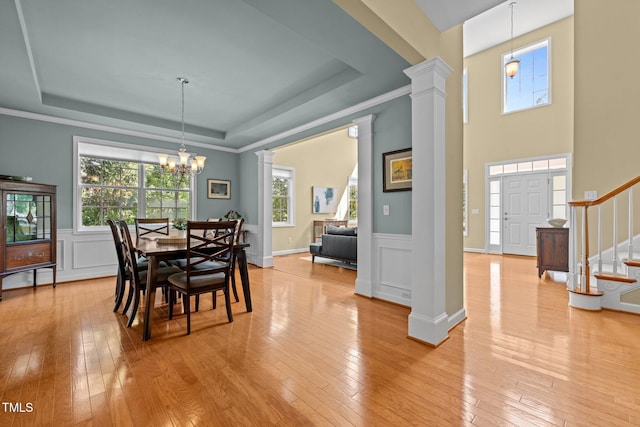 705 Harkness Cir, Durham, NC 27705 - dining area featuring a tray ceiling, stairs, ornate columns, light wood finished floors, and a wainscoted wall