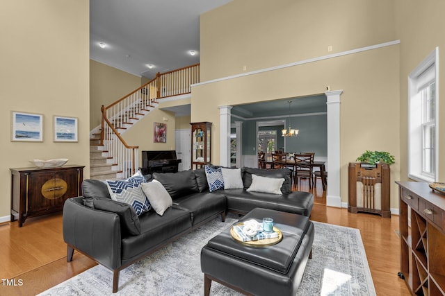 705 Harkness Cir, Durham, NC 27705 - living room with a towering ceiling, plenty of natural light, ornate columns, and light wood finished floors