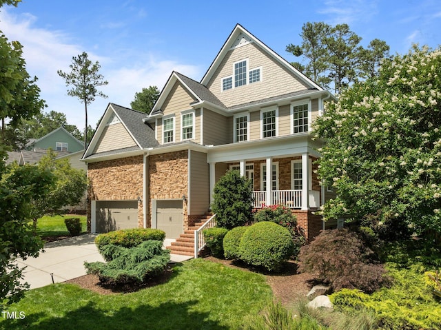 705 Harkness Cir, Durham, NC 27705 - view of front facade with a porch, concrete driveway, stone siding, and stairway