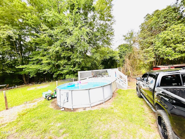 1337 Maple St, Rocky Mount, NC 27803 - view of grassy yard featuring view of wooded area, an outdoor pool, and a wooden deck