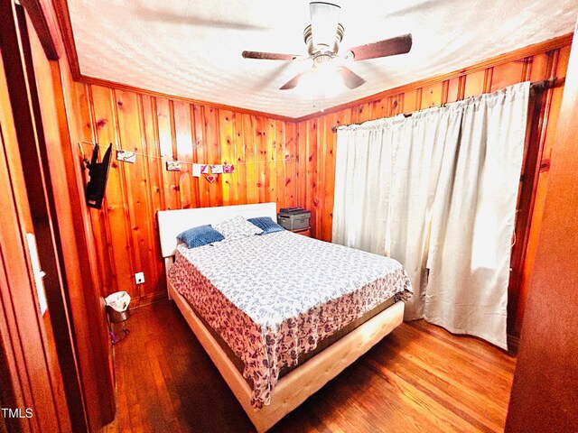 1337 Maple St, Rocky Mount, NC 27803 - bedroom with wood finished floors, wooden walls, and a ceiling fan