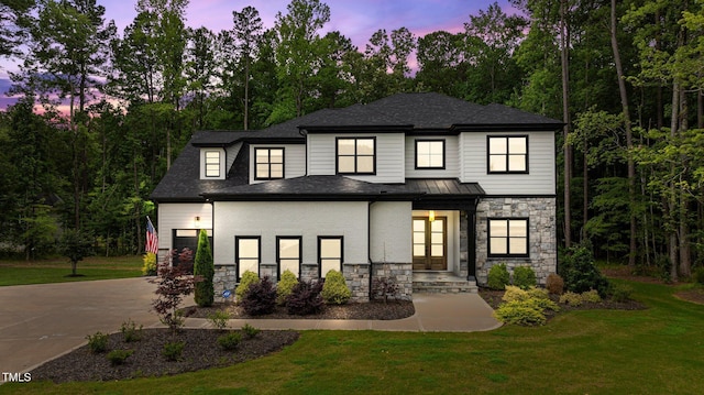310 Hidden Lake Dr, Youngsville, NC 27596 - view of front facade with stone siding, a front lawn, driveway, and a garage