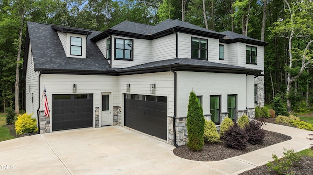 310 Hidden Lake Dr, Youngsville, NC 27596 - view of front of property featuring stone siding, concrete driveway, an attached garage, roof with shingles, and view of scattered trees