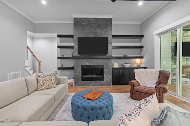 310 Hidden Lake Dr, Youngsville, NC 27596 - living area featuring wood finished floors, crown molding, a high end fireplace, recessed lighting, and stairs