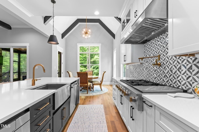 310 Hidden Lake Dr, Youngsville, NC 27596 - kitchen featuring exhaust hood, white cabinetry, appliances with stainless steel finishes, light countertops, and vaulted ceiling