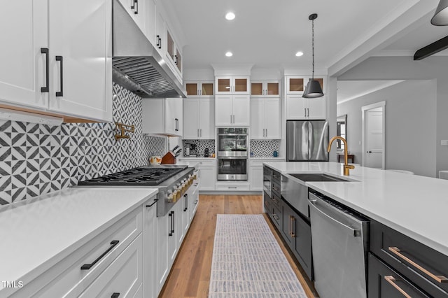 310 Hidden Lake Dr, Youngsville, NC 27596 - kitchen with appliances with stainless steel finishes, extractor fan, light countertops, white cabinets, and hanging light fixtures