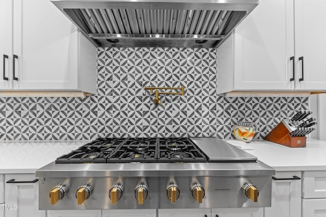 310 Hidden Lake Dr, Youngsville, NC 27596 - kitchen featuring wall chimney exhaust hood, stainless steel gas cooktop, light countertops, white cabinetry, and backsplash