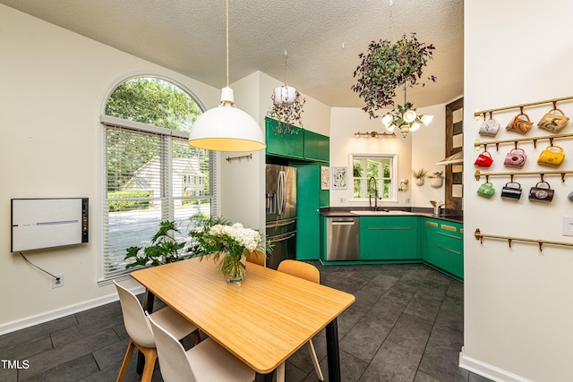 3616 Culater Ct, Raleigh, NC 27616 - kitchen featuring stainless steel appliances, a textured ceiling, green cabinetry, hanging light fixtures, and dark countertops