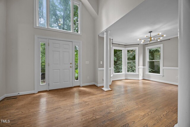 6001 Waters Way Dr, Raleigh, NC 27606 - foyer with ornate columns, a chandelier, wood finished floors, and a high ceiling