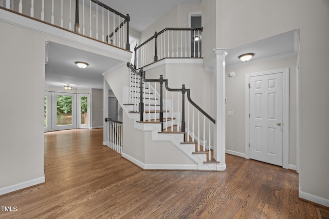 6001 Waters Way Dr, Raleigh, NC 27606 - stairway featuring wood finished floors, a towering ceiling, ornate columns, and ornamental molding