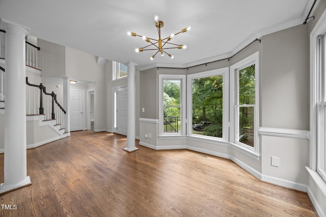 6001 Waters Way Dr, Raleigh, NC 27606 - unfurnished living room featuring ornate columns, crown molding, wood finished floors, stairs, and a chandelier