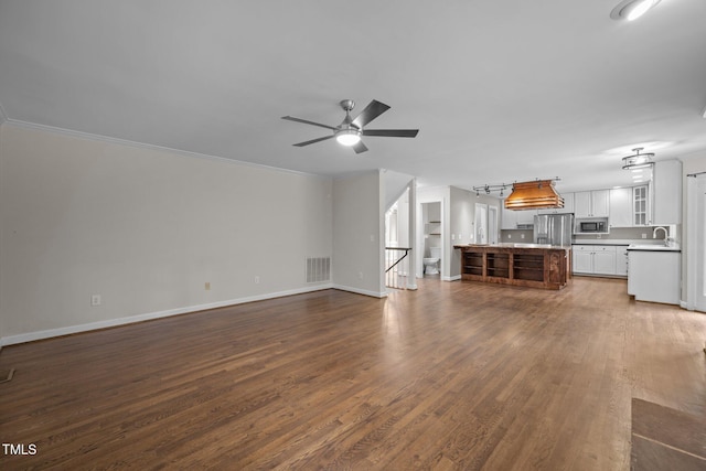 6001 Waters Way Dr, Raleigh, NC 27606 - unfurnished living room featuring dark wood-style flooring, ceiling fan, and crown molding