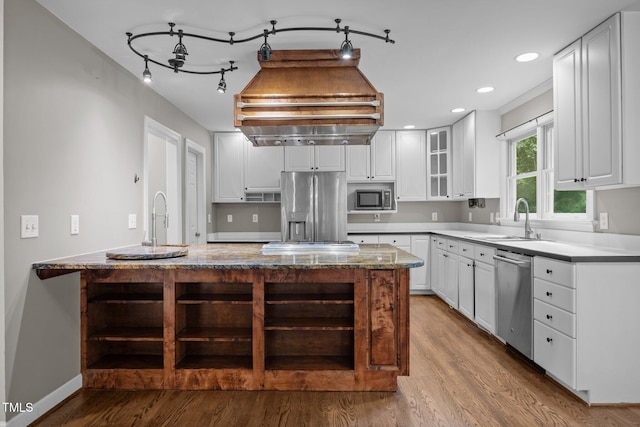 6001 Waters Way Dr, Raleigh, NC 27606 - kitchen with stainless steel appliances, wood finished floors, white cabinets, glass insert cabinets, and light stone counters