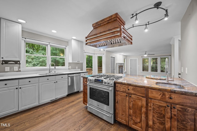 6001 Waters Way Dr, Raleigh, NC 27606 - kitchen with stainless steel appliances, custom exhaust hood, white cabinetry, a ceiling fan, and ornamental molding