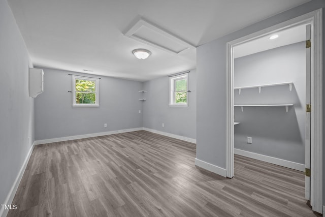 6001 Waters Way Dr, Raleigh, NC 27606 - unfurnished bedroom featuring attic access, wood finished floors, and multiple windows