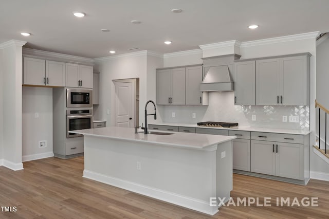 4824 Bristol Meadow Dr, Raleigh, NC 27603 - kitchen with stainless steel appliances, gray cabinetry, an island with sink, custom exhaust hood, and light countertops