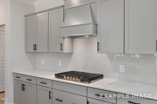 4824 Bristol Meadow Dr, Raleigh, NC 27603 - kitchen featuring custom range hood, light countertops, crown molding, gray cabinetry, and stainless steel gas cooktop