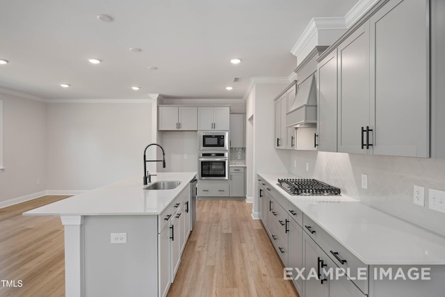 4824 Bristol Meadow Dr, Raleigh, NC 27603 - kitchen with appliances with stainless steel finishes, crown molding, light wood-style flooring, decorative backsplash, and a kitchen island with sink