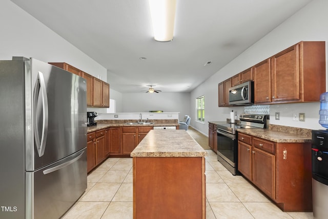 702 Pitch Pine Dr, Creedmoor, NC 27522 - kitchen featuring stainless steel appliances, a ceiling fan, a kitchen island, and light tile patterned flooring