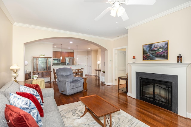 7250 NC-751 Hwy, Durham, NC 27707 - living room featuring a ceiling fan, dark wood-type flooring, arched walkways, ornamental molding, and a glass covered fireplace