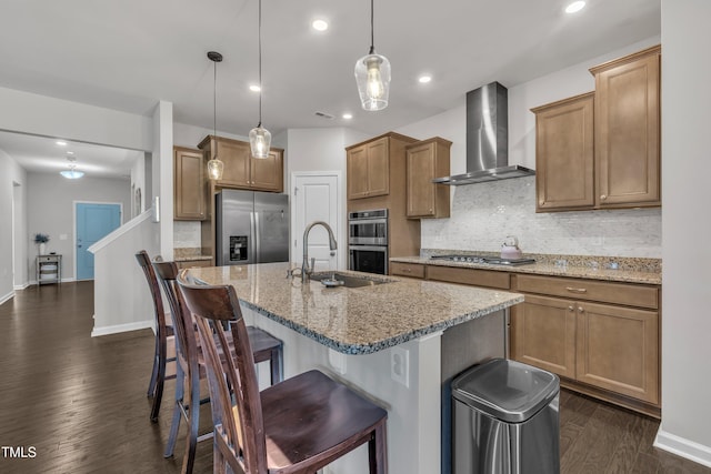 2626 Nassau Trce, Fuquay Varina, NC 27526 - kitchen featuring stainless steel appliances, wall chimney exhaust hood, dark wood finished floors, decorative backsplash, and a breakfast bar