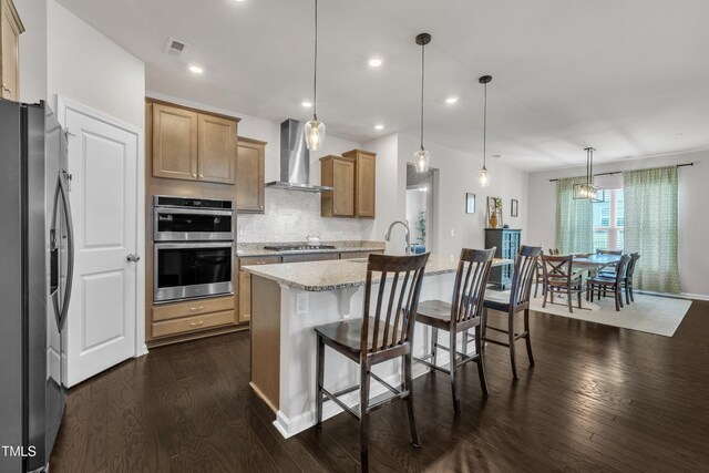 2626 Nassau Trce, Fuquay Varina, NC 27526 - kitchen with appliances with stainless steel finishes, wall chimney range hood, dark wood-type flooring, light stone countertops, and tasteful backsplash