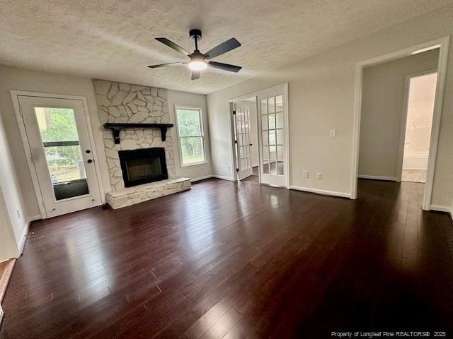 162 E Twelve Oaks Rd, Raeford, NC 28376 - unfurnished living room with dark wood-type flooring, a textured ceiling, plenty of natural light, and a ceiling fan