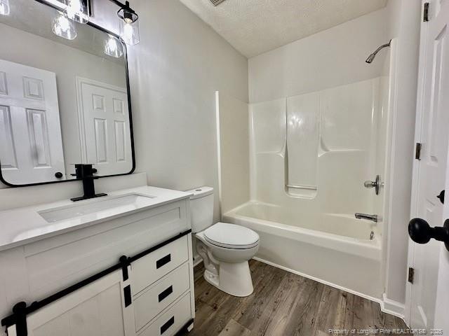 162 E Twelve Oaks Rd, Raeford, NC 28376 - full bathroom with vanity, wood finished floors, shower / bath combination, and a textured ceiling