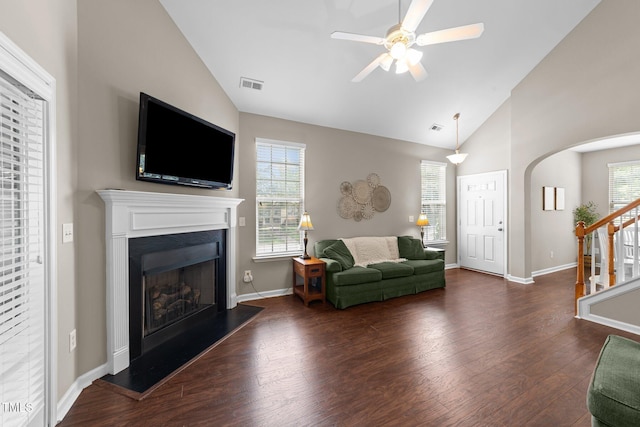 100 Tobacco Leaf Ln, Apex, NC 27502 - living room featuring vaulted ceiling, wood finished floors, a ceiling fan, stairs, and a fireplace with raised hearth
