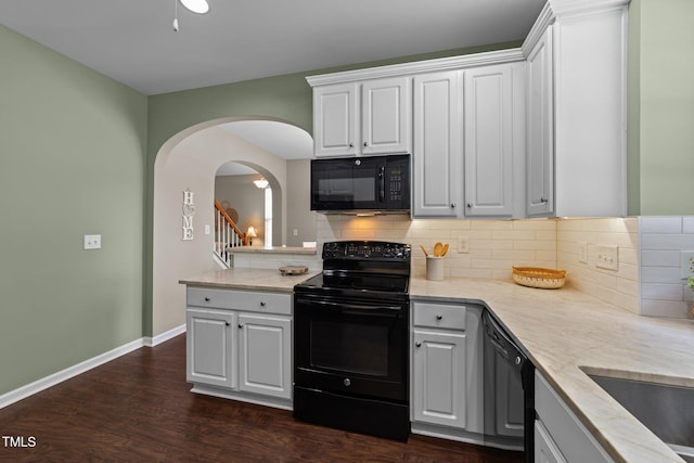 100 Tobacco Leaf Ln, Apex, NC 27502 - kitchen featuring black appliances, arched walkways, decorative backsplash, dark wood-style floors, and white cabinetry