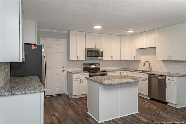2110 Lombardy Dr, Fayetteville, NC 28304 - kitchen with appliances with stainless steel finishes, white cabinets, dark wood-style floors, a textured ceiling, and tasteful backsplash