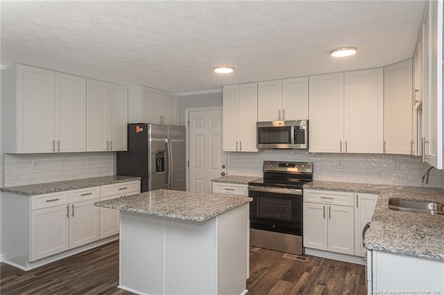 2110 Lombardy Dr, Fayetteville, NC 28304 - kitchen featuring appliances with stainless steel finishes, dark wood finished floors, white cabinets, a textured ceiling, and recessed lighting