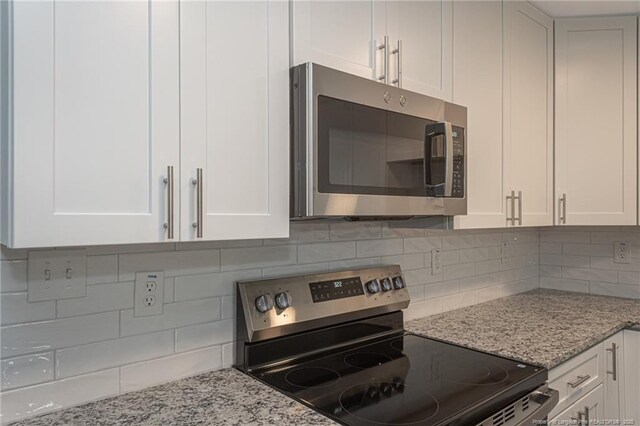 2110 Lombardy Dr, Fayetteville, NC 28304 - kitchen with appliances with stainless steel finishes, white cabinetry, light stone countertops, and backsplash